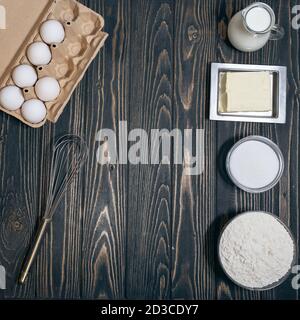 Blick von oben auf Mehl, eeg, Milch und Zucker auf dem Schreibtisch in der Küche Stockfoto