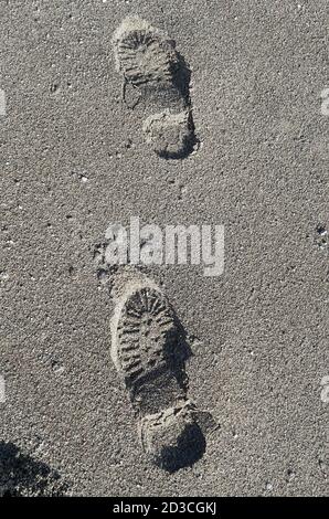 Schuhfußabdruck auf einem Sandstrand Stockfoto