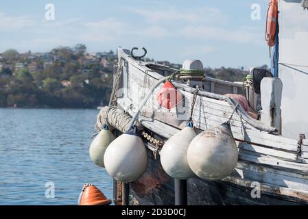 Eine Reihe von Bojen hängt an der Seite eines alten Holzschleppers im Sydney Harbour, New South Wales, Australien Stockfoto