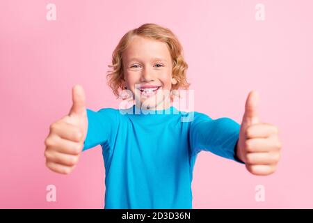 Foto von kleinen Jungen heben zwei Daumen nach oben Symbol toothy Lächeln tragen blau Rollkragen isoliert pastellrosa Farbe Hintergrund Stockfoto