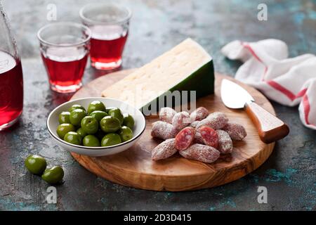 Antipasto-Platte. Fuet Mini Würste, grüne Oliven und Käse auf Holz Schneidebrett, selektive Fokus Stockfoto
