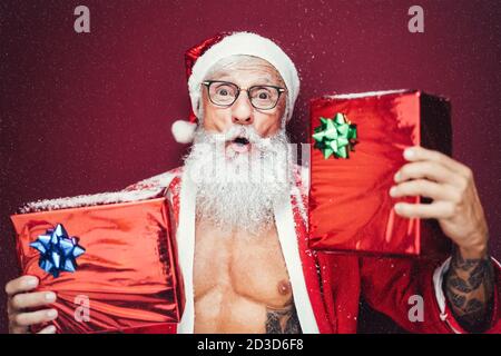 Happy Santa Claus hält Weihnachtsgeschenke - Hipster bärtig Senior Mit Spaß tragen Weihnachtskleidung feiern Urlaub Stockfoto