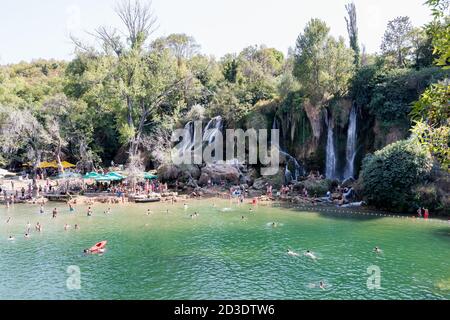 STUDENCI, BOSNIEN-HERZEGOWINA - 2017. AUGUST 16. Kravice Wasserfälle in Bosnien-Herzegowina, Touristen genießen Kravice Wasserfälle an einem heißen Sommertag. Stockfoto