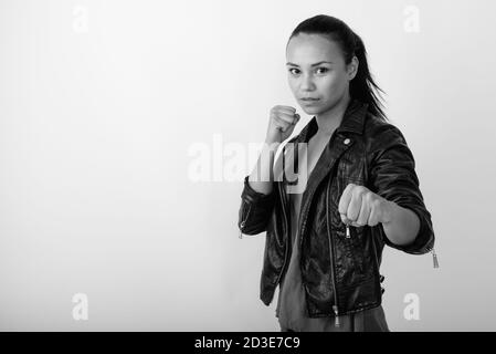 Studio Aufnahme der jungen asiatischen Frau trägt Lederjacke bereit Gegen weißen Hintergrund zu kämpfen Stockfoto