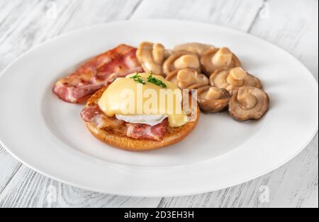 Eier Benedikt mit Speck auf dem Teller Stockfoto