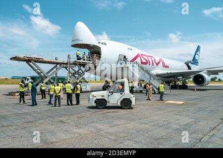 Eine Boeing B747 Jumbo Jet Frachter Flugzeug mit einem breiten Öffnen Sie die Nasentür, die von einem Hochlader an entladen wird Eine Laderampe Stockfoto