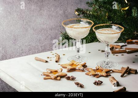 Eierlikör Weihnachten Milch Cocktail, in zwei vintage Crystal serviert Gläser mit SHORTBREAD Stern Sugar Cookies, Zimtstangen, tanne Zweig über Weiß Stockfoto