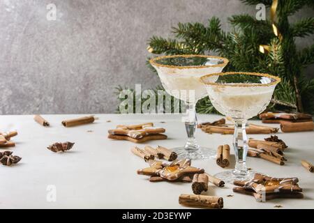 Eierlikör Weihnachten Milch Cocktail, in zwei vintage Crystal serviert Gläser mit SHORTBREAD Stern Sugar Cookies, Zimtstangen, tanne Zweig über Weiß Stockfoto