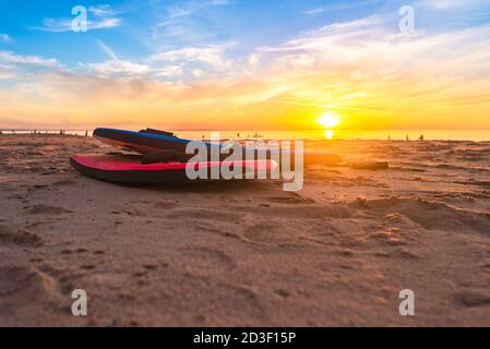 Schwimmen Bodyboards auf dem Sand bei Sonnenuntergang, Christies Beach, South Australia Stockfoto