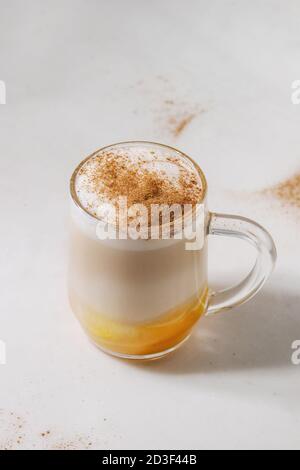 Glas Kürbis layered Spice Latte mit kürbispüree, Milchschaum und Zimt auf weißem Marmor tisch. Platz kopieren Stockfoto