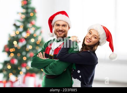 Glückliches Paar in Weihnachten Pullover und Santa Hüte Stockfoto