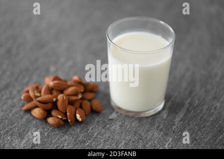 Glas laktosefreie Milch und Mandeln auf dem Tisch Stockfoto