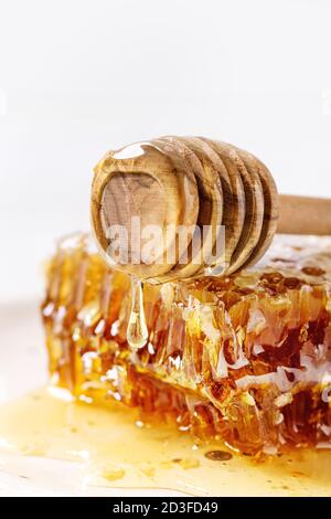 Bio Honig in den Waben aus Holz- pendelarm auf weißem Hintergrund. Nahaufnahme Stockfoto