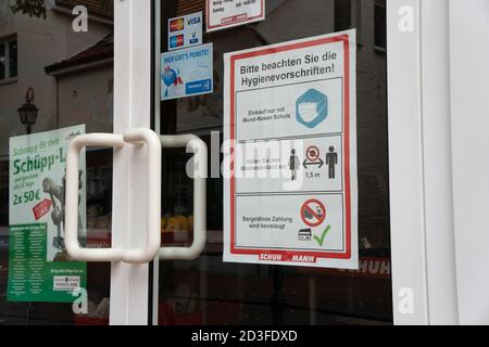 Plakat im Schaufenster Beratung der sozialen Distanzierung und Verwendung von Gesichtsmaske. Ostfriesland. Deutschland. Stockfoto