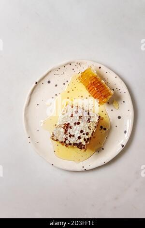 Bio Honig in den Waben in beschmutzt Keramikplatte auf weißem Hintergrund. Flach, kopieren Raum Stockfoto