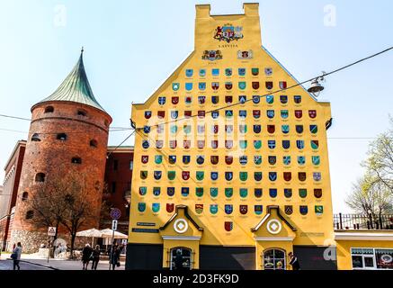 Pulverturm (Pulvertornis) und Gebäude mit den Emblemen der Städte Lettlands in Riga. Stockfoto