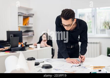 Junger Ingenieur bei der Arbeit, Erstellen von Baumodellen und technische Zeichnungen. Stockfoto