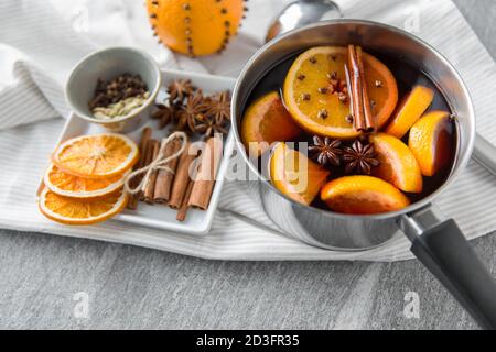 Topf mit heißem Glühwein, Orangenscheiben und Gewürzen Stockfoto