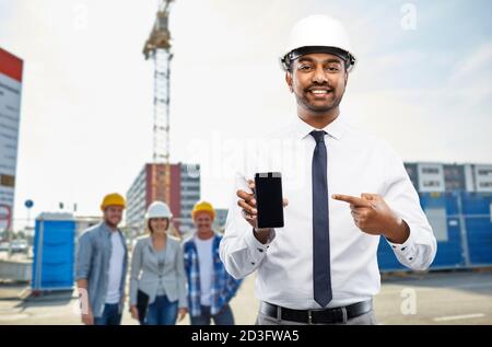 Architekt zeigt Smartphone auf der Baustelle Stockfoto