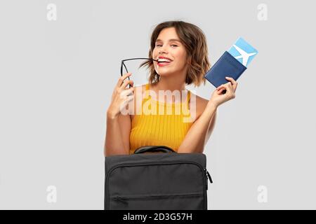Glückliche junge Frau mit Flugticket und Reisetasche Stockfoto
