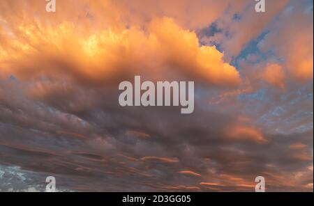 Sturmwolken sammeln sich über dem Meer, aber während die Sonnenuntergänge, die Strahlen mischen sich mit den Wolken und hat einen schönen orange-gelben Farbton. Stockfoto