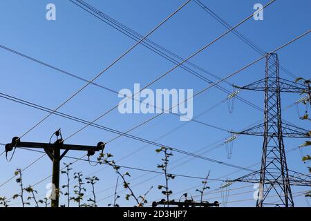 Telefonleitungen und Übertragungskabel des Turms werden zu einem Gitter auf blauem Himmel Hintergrund Stockfoto