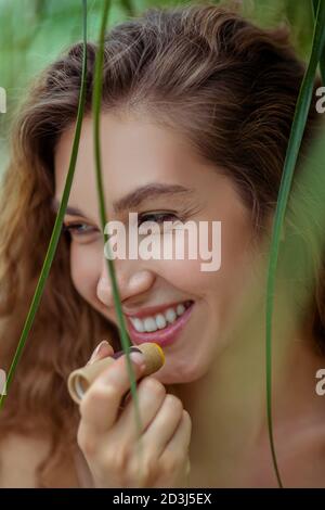 Hübsche junge Frau, die Lippenbalsam auf ihre Lippen setzt Stockfoto