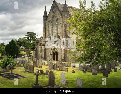 Vorderansicht der St. Canice's Cathedral in Kilkenny in Irland mit Gräbern und Grabsteinen im Vordergrund. Stockfoto