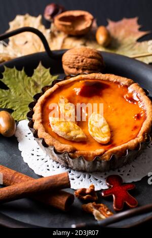 Herbst Food-Konzept hausgemachte Bio rustikalen Kürbisse Kuchen dekorieren durch Herbstlaub auf schwarzem Hintergrund mit Kopierplatz Stockfoto