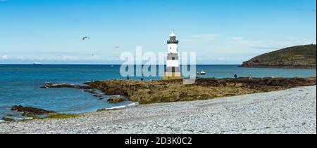 Trwyn Du Lighthouse in Penmon, Anglesey, Wales mit der Fähre, die früher Airbus-Flügel nach Frankreich transportieren sollte, die auf der Flut vor der Küste warten Stockfoto