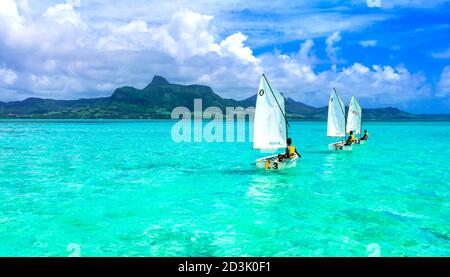 Atemberaubende Blue Bay mit transparentem türkisfarbenem Meer. Jungs in Segelbooten. Mauritius-Insel. Januar 2020 Stockfoto