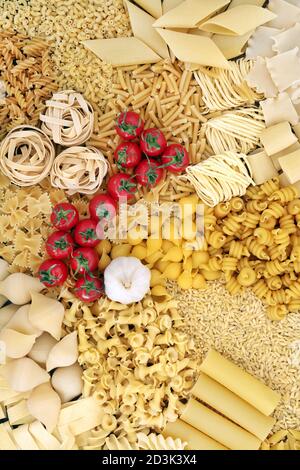 Gesunde italienische Zutaten mit Nudelsorten, Tomaten und Knoblauch. Flach liegend, Draufsicht. Stockfoto