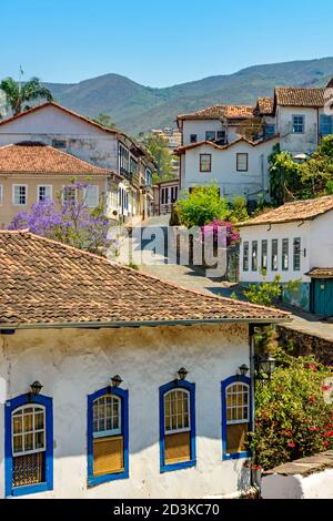 Ruhige Straße mit alten bunten Häusern in Kolonialarchitektur, Kopfsteinpflaster und Laternen für Beleuchtung in Ouro Preto Stadt Stockfoto