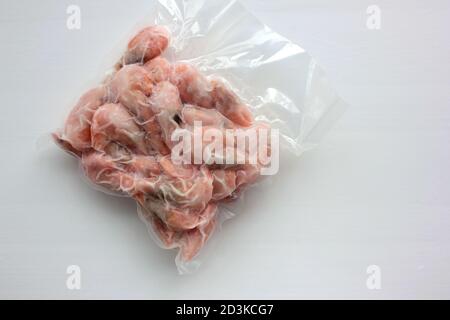 Gekochte und gefrorene Garnelen in vakuumtransparentem Plastikverpackungsbeutel auf weißem Hintergrund. Stockfoto