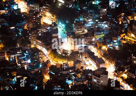 Größter Slum Südamerikas, Favela da Rocinha, in Rio de Janeiro. Luftaufnahme bei Nacht mit beleuchteten Straßen und Häusern. Stockfoto