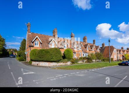 Blick auf typische rote Backstein-Reihenhäuser und Häuser in der Hauptstraße von Great Bedwyn, einem Dorf im Osten Wiltshire, Südengland Stockfoto