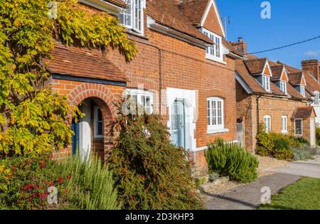 Blick auf typische rote Backstein-Reihenhäuser und Häuser in der Hauptstraße von Great Bedwyn, einem Dorf im Osten Wiltshire, Südengland Stockfoto