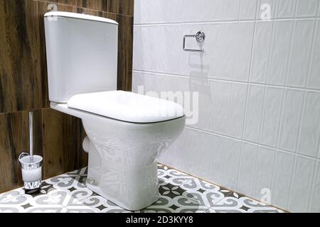 Moderne Toilettenschüssel mit einem Tank wird mit einem Deckel geschlossen. Fast die Kapazität der Bürste mit einer Desinfektionslösung Stockfoto