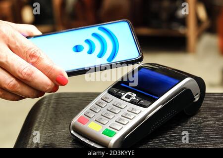 Bezahlung per Smartphone im Zahlungsterminal. Elektronisches Geld. Mobile Banking. Einkaufskomplex. Stockfoto