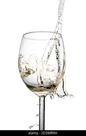 Spritzer von weißem Sekt in einem Glas auf einem weißen isolierten Hintergrund. Nahaufnahme Stockfoto