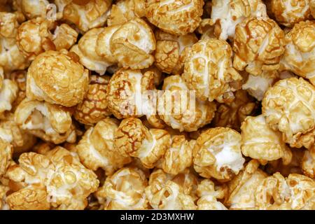 Popcornmuster. Ein Haufen Popcorn. Süßigkeiten. Popcornmuster. Karamell Popcorn strukturierten Hintergrund. Essen, Kino, Film. Draufsicht. Stockfoto