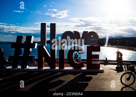 NICE, FRANCE-MAY,29,2019: Tourist poses for a photo near the I love Nice Tourist sign Installation above Promenade des Anglais in City of Nice Stockfoto