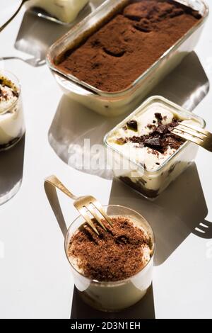 Tiramisu in verschiedenen Formen, verschiedene Form des Servierens Tiramisu, auf Gläsern, klassisch, und als Rundkuchen, Stockfoto