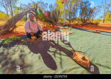Kings Creek Station, Northern Territory, Australien - 21. Aug 2019: Australischer Aborigine-Guide zeigt Buschsamen, Nahrung und medizinische Pflanzen während der Stockfoto