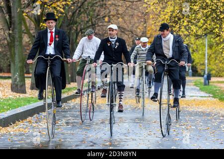 Gruppe von Herren auf Penny Farthing Fahrräder hohe Räder Männer Gruppenfahrt im Park Stockfoto