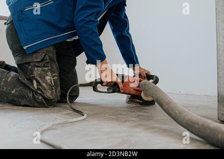 Bauarbeiter mit Maschine Polieren Oberfläche Boden Glättung und Finishing Härter oder Epoxidbeton in der Fabrik. Stockfoto