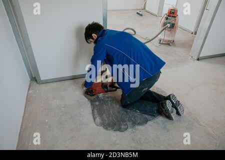 Bauarbeiter mit Maschine Polieren Oberfläche Boden Glättung und Finishing Härter oder Epoxidbeton in der Fabrik. Stockfoto