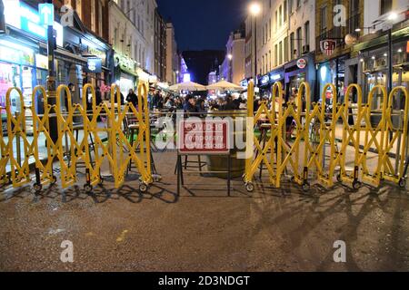 Temporäre Straßensitzplätze in Bars und Restaurants in der Old Compton Street, Soho, London mit Covid-19-Schild, September 2020 Stockfoto