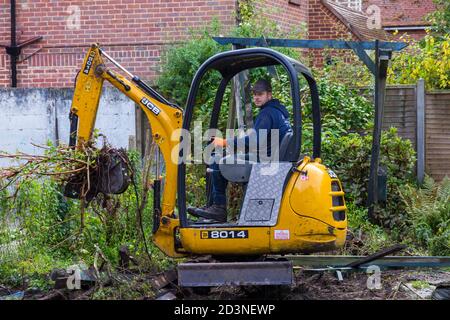 Gartenarbeit und Renovierung Teilnahme an Garten in Bournemouth, Dorset UK im Oktober - Arbeiter Betrieb jcb Mini Bagger Stockfoto