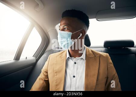 Junger Mann Trägt Maske Im Rücken Von Taxi Während Der Gesundheit Pandemie Geht Am Datum Aus Stockfoto